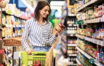 Vrouw leest het etiket van een product in de supermarkt