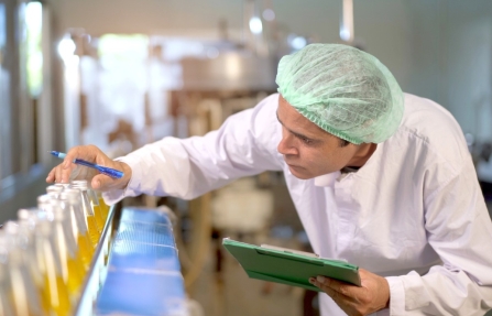 Collaborateur qualité contrôlant des produits sur une ligne de production